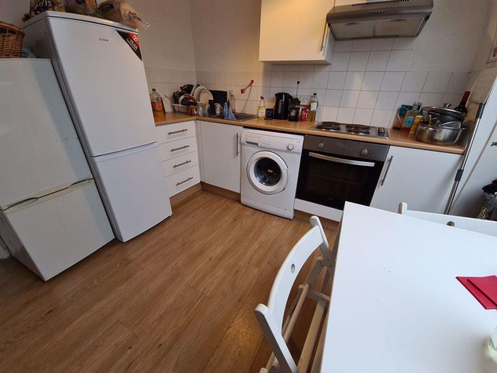 Bright, modern kitchen with wooden-style floori...