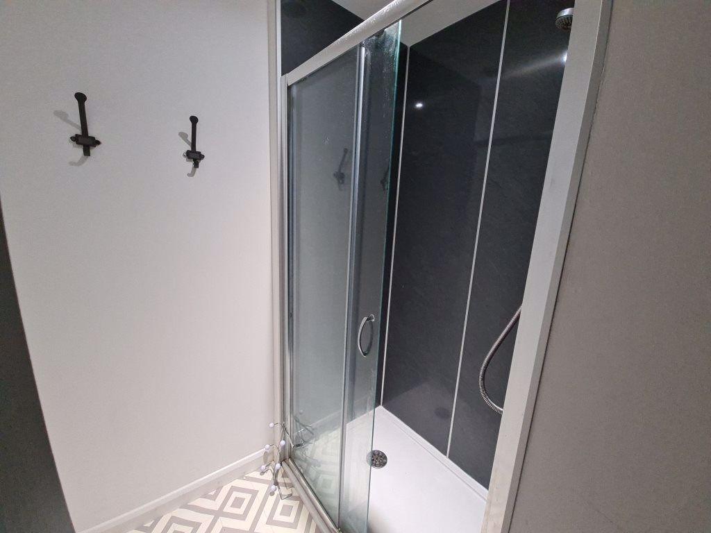 A neat, modern bathroom featuring a glass-enclo...