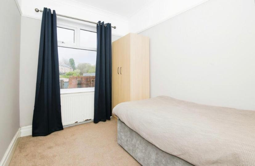 Bright, simply furnished single bedroom with a ...