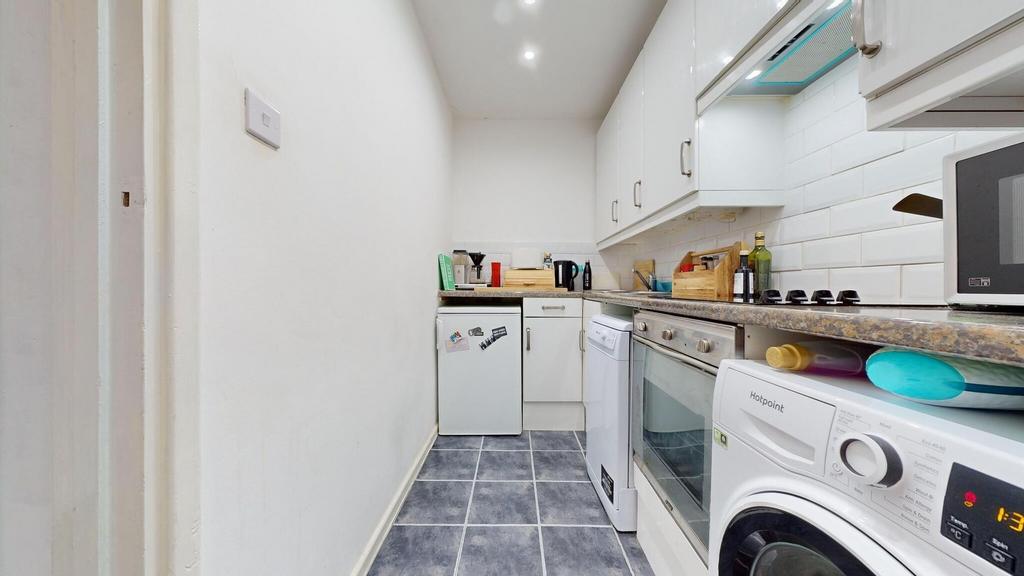 Bright, modern galley kitchen with tiled floor,...