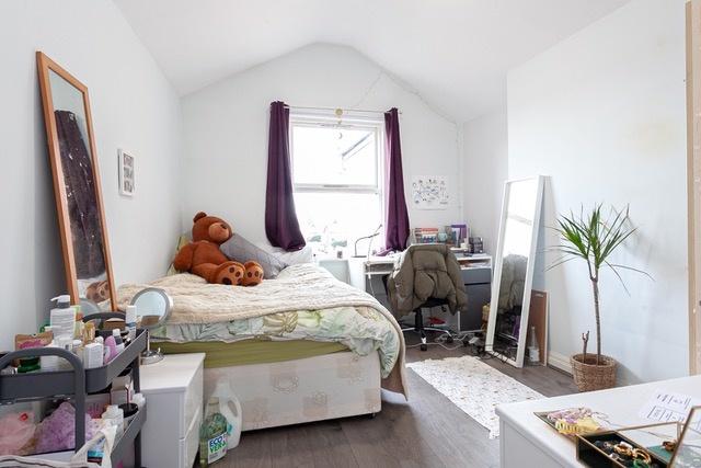 Bright, cozy bedroom with large window and stor...