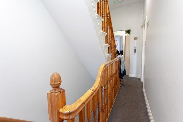 Bright carpeted landing with wooden banister...