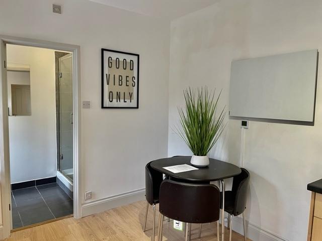 Bright kitchenette/dining nook with a round bla...