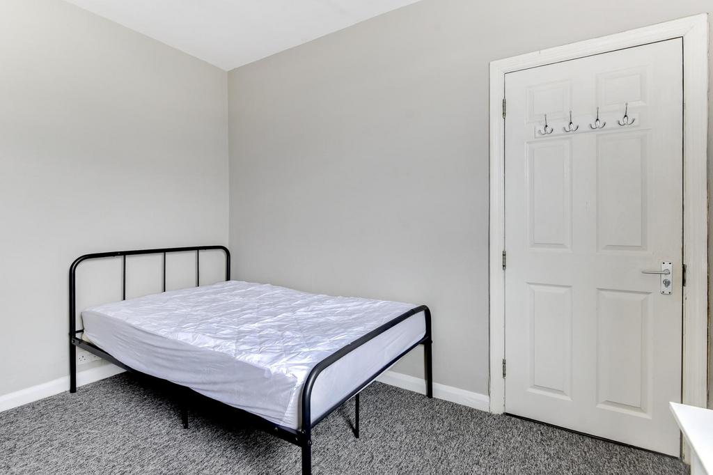 Bright, neutrally decorated bedroom with a simp...