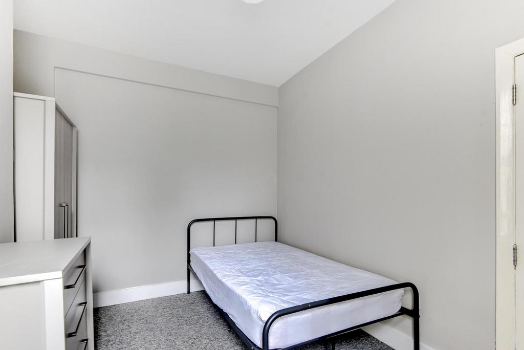 Neat single bedroom with a simple metal-framed ...