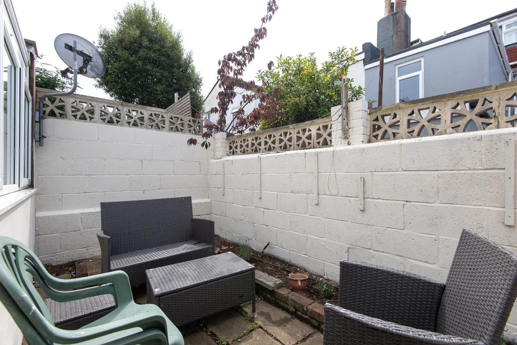 Enclosed rear courtyard with patio seating and ...
