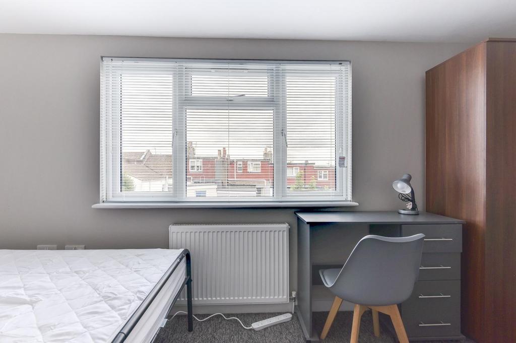 Bright, simply furnished bedroom with a large w...