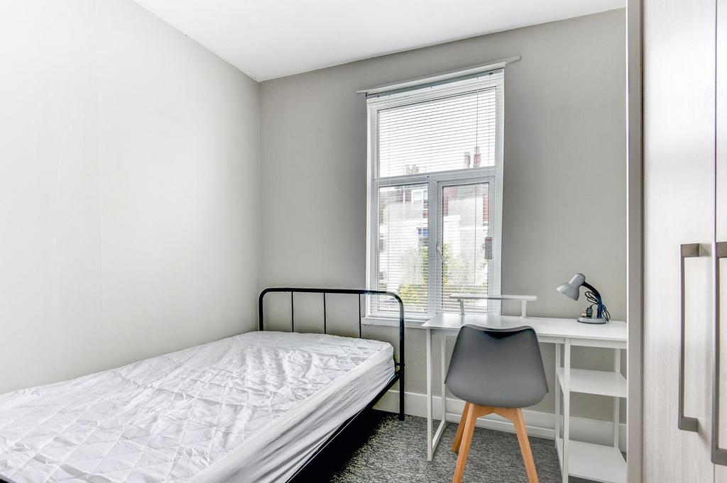 A neatly maintained single bedroom featuring a ...