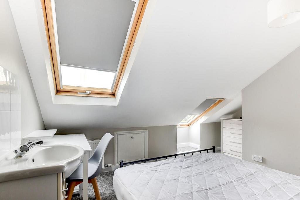 Bright and airy bedroom featuring a skylight wi...