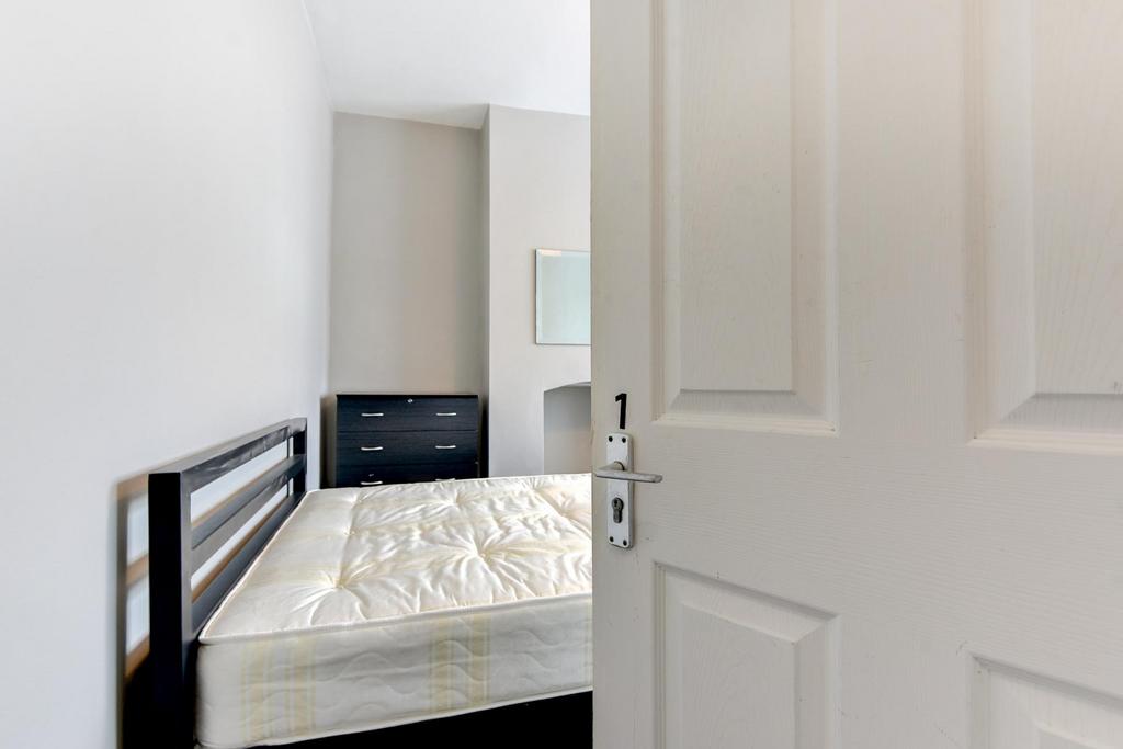 A bright and tidy bedroom with a comfortable do...