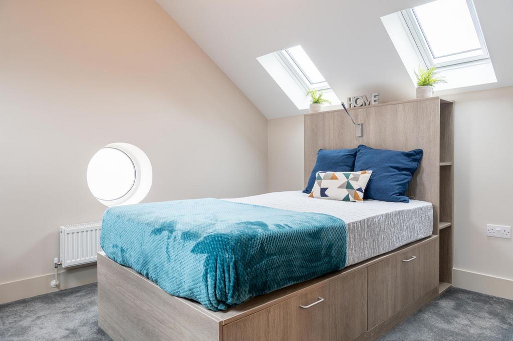 Bright, neatly styled bedroom with a built-in s...