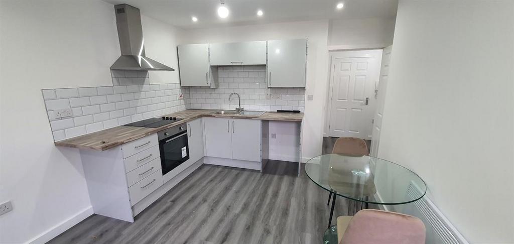 Modern open-plan kitchen with pale cabinetry, s...