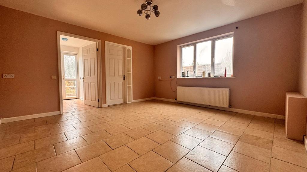 Bright, tiled living room with large window...