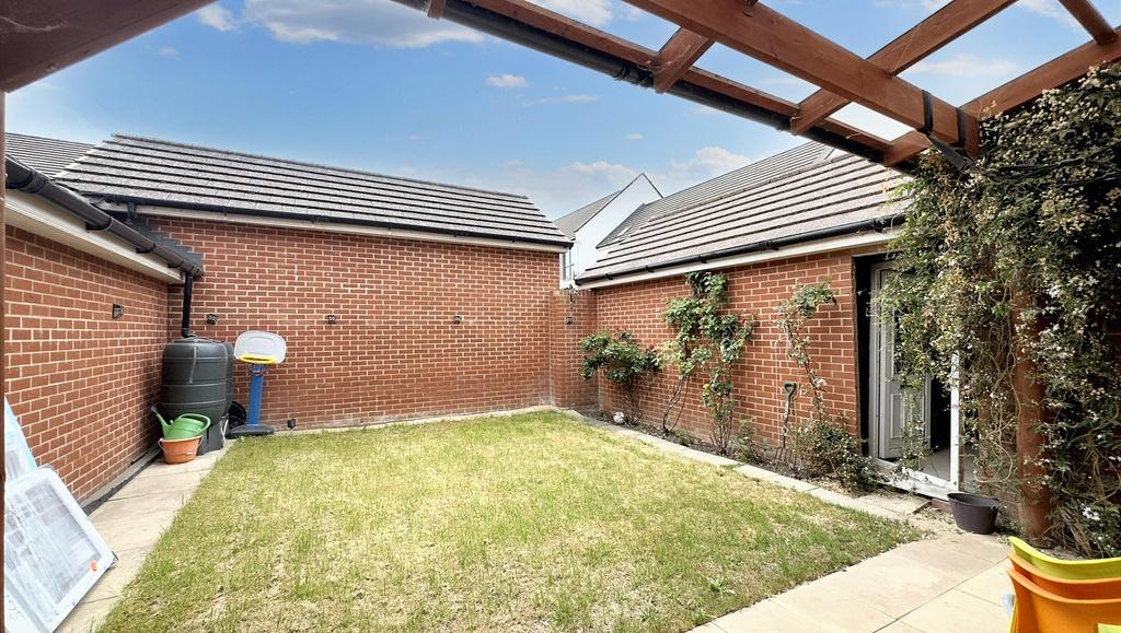 Private sunny courtyard garden with lawn and pa...