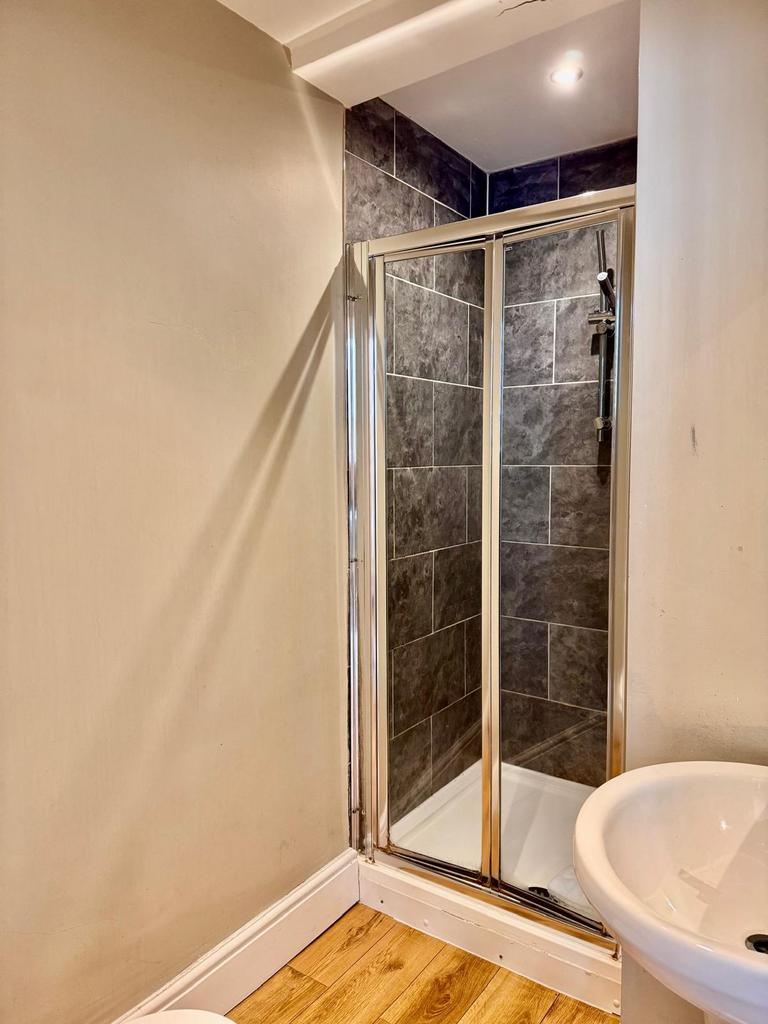Modern tiled shower with basin and wood-effect ...