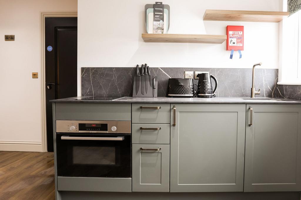 Modern kitchen with appliances and marble-lookw...