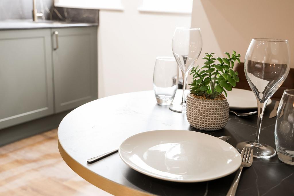 Stylish set dining table with plant and glasswa...
