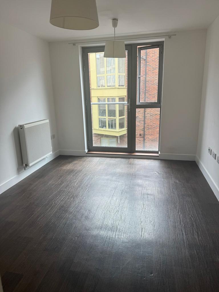 Bright room with floor-to-ceiling window and da...