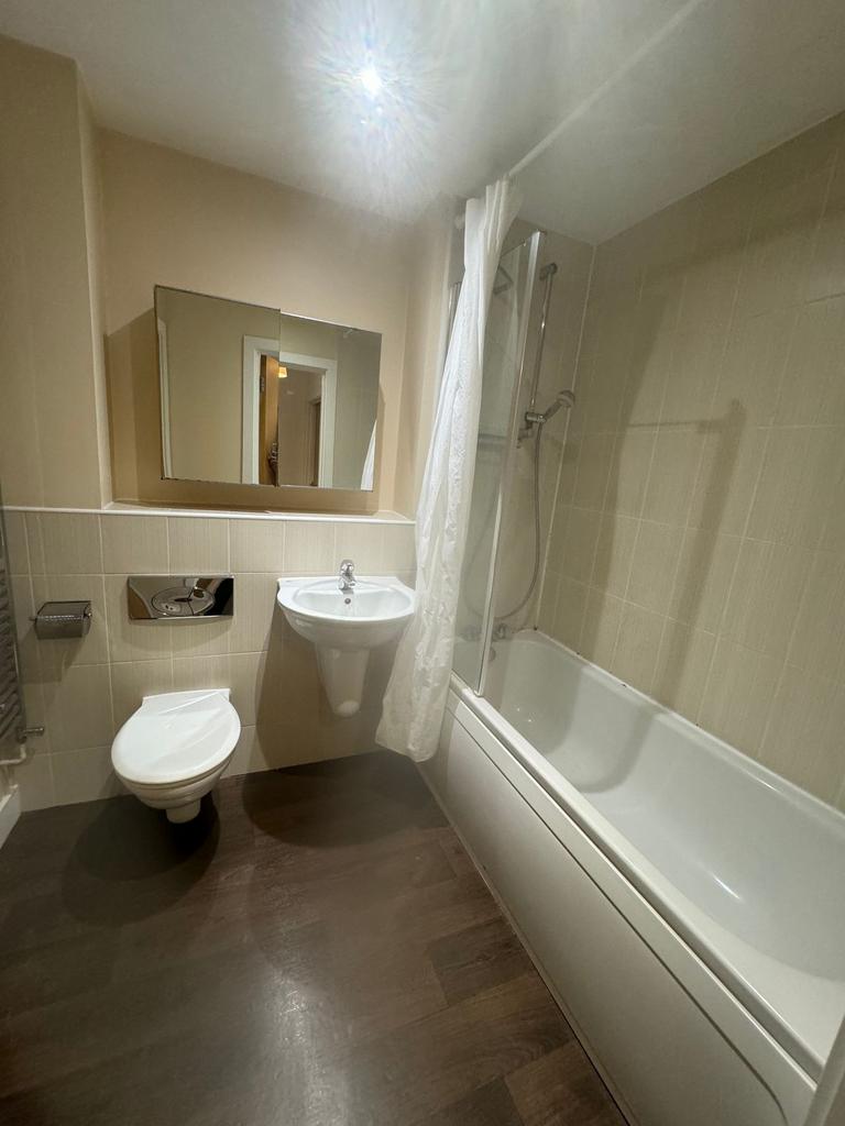 Modern bathroom with shower over bath...