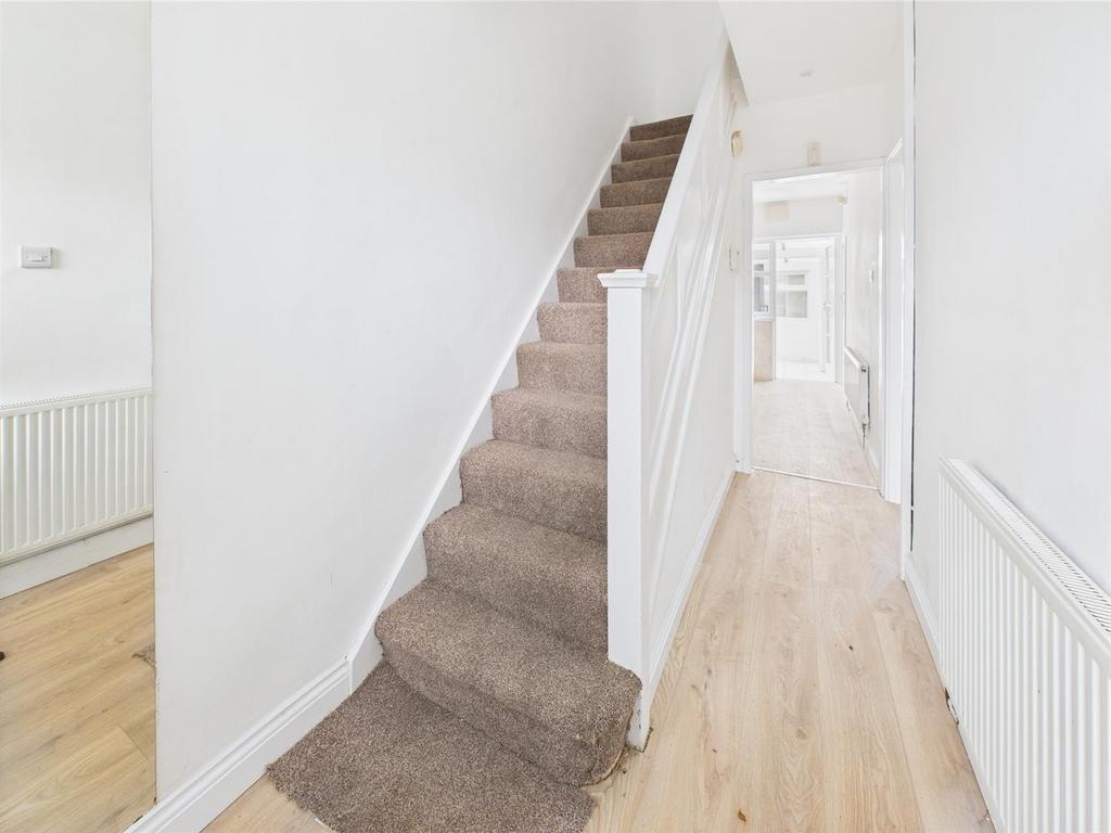 Bright hallway with stairs and wood flooring...