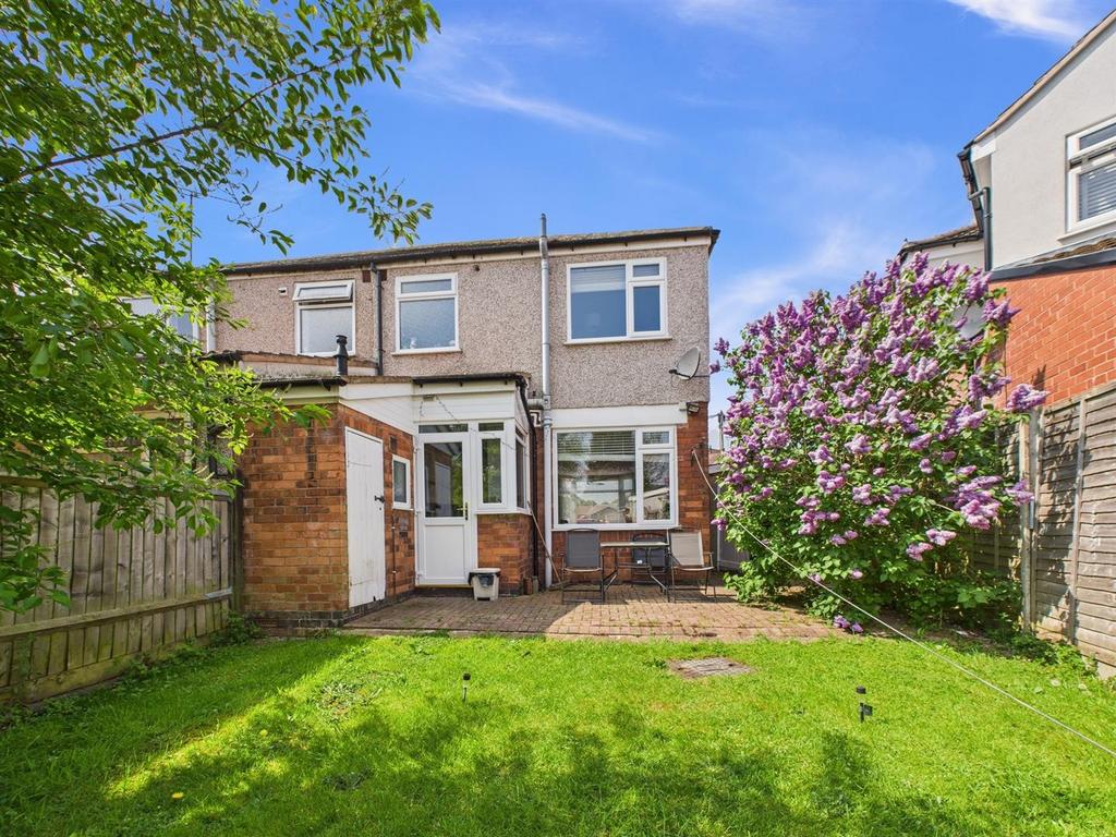 Sunny rear garden with lawn and patio...