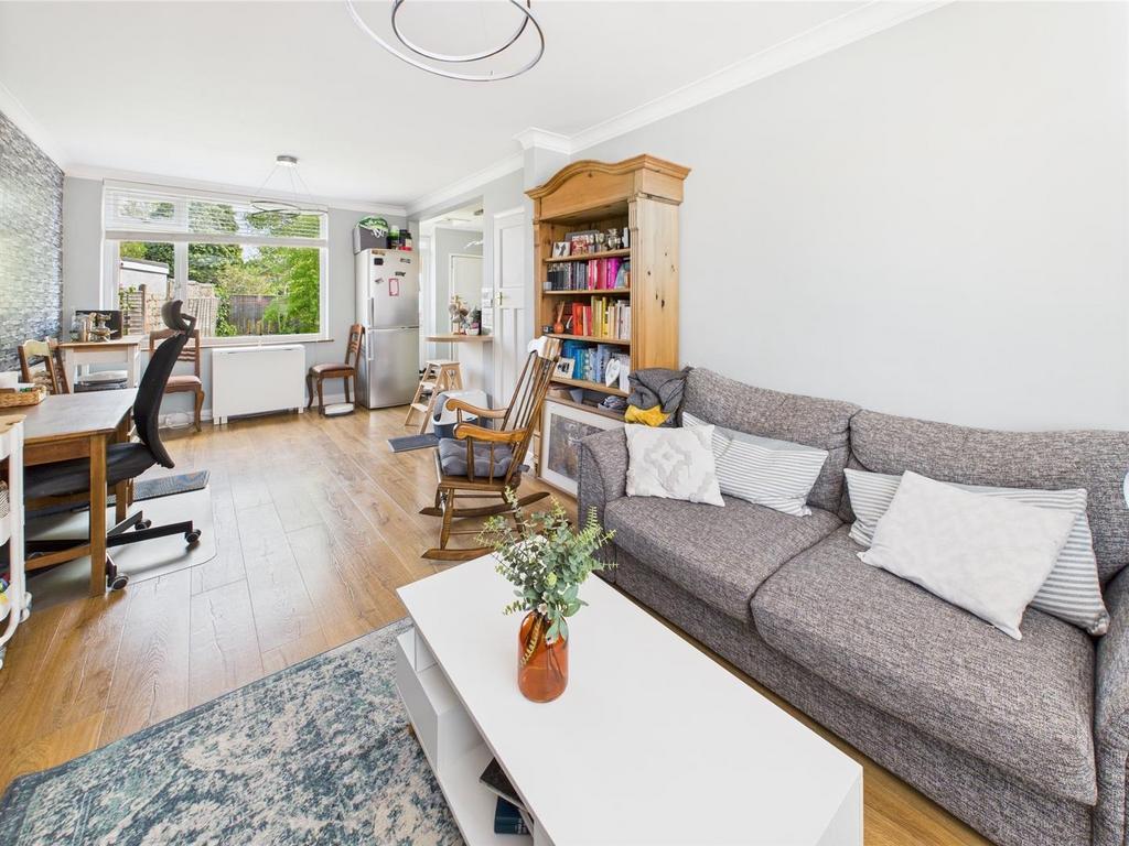 Bright open-plan living area with sofa and desk...