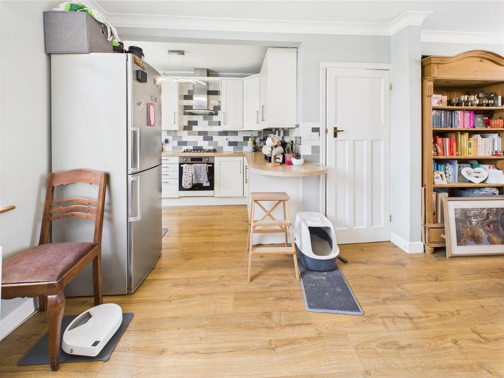 Open-plan kitchen with wooden floors and storag...