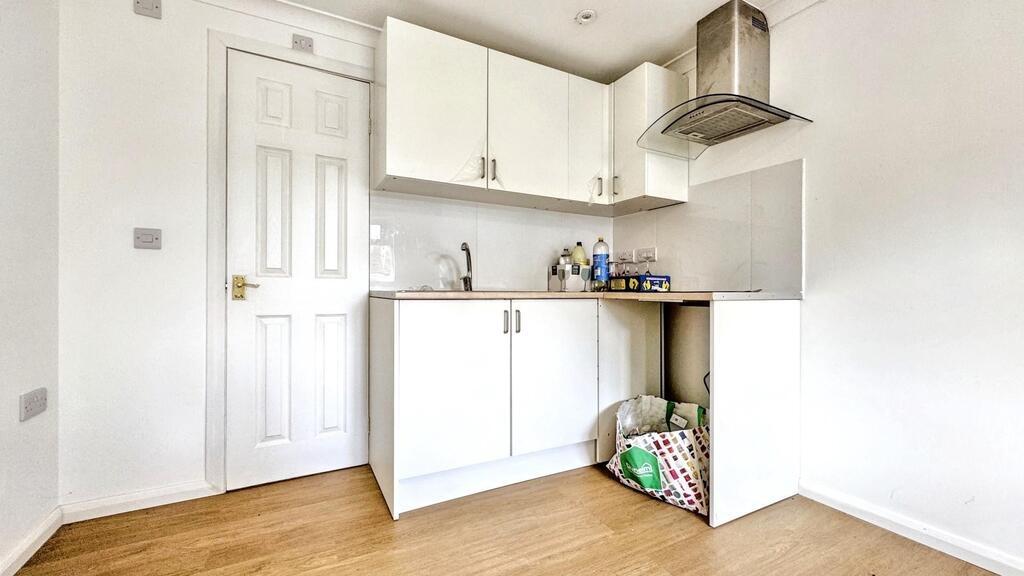 Bright compact kitchen with white units...