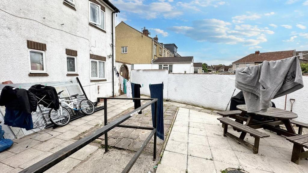 Sunny paved communal courtyard with seating...