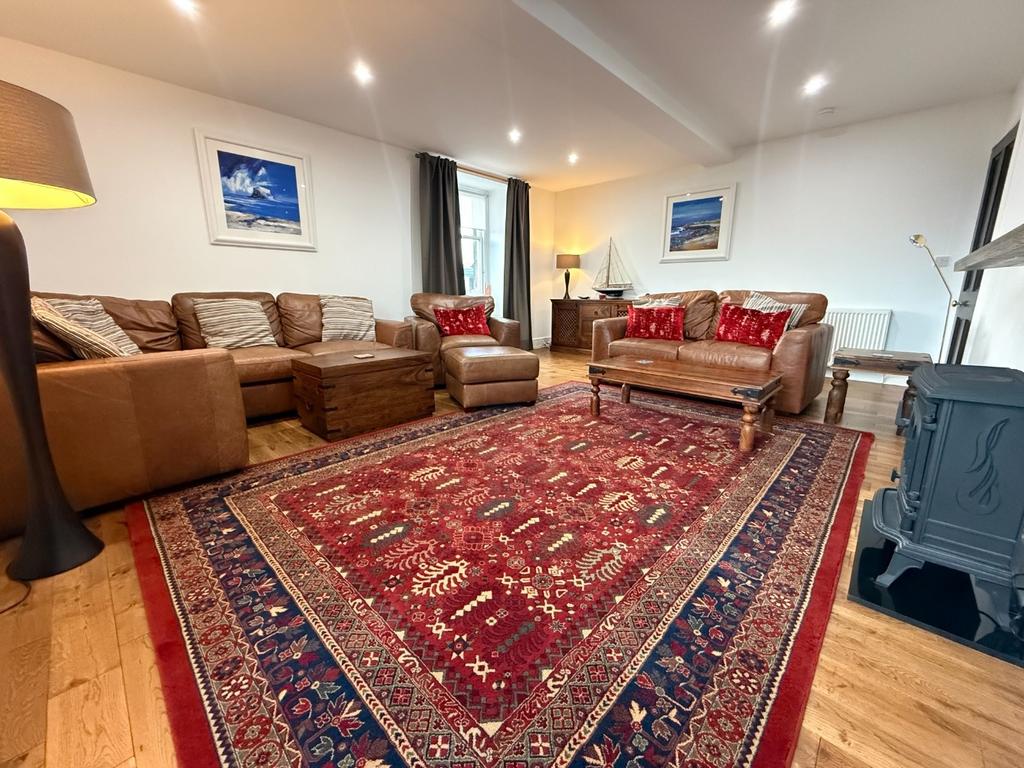 Spacious, well-lit living room with comfy seati...