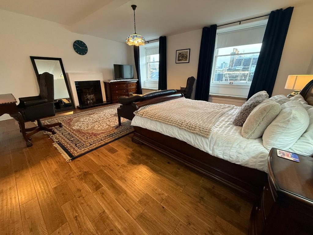 Spacious bedroom with large bed and natural lig...