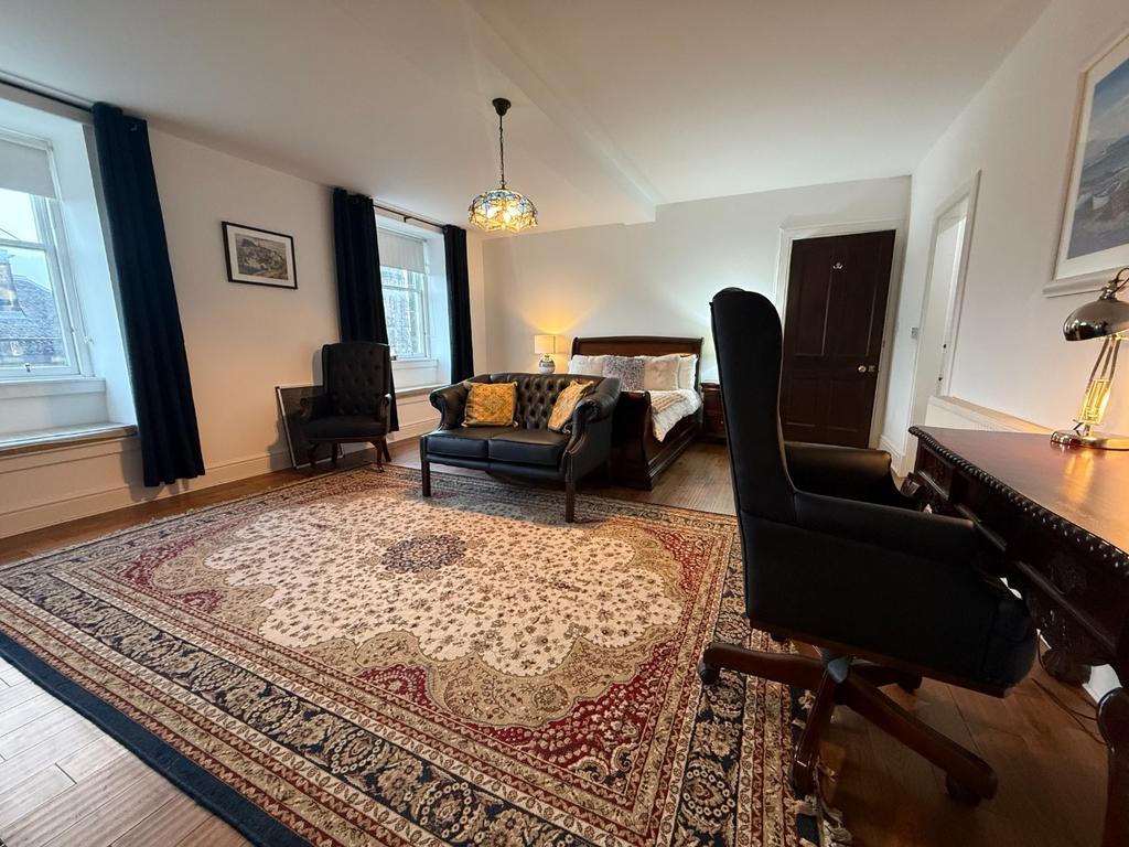 Spacious living room with large rug and seating...
