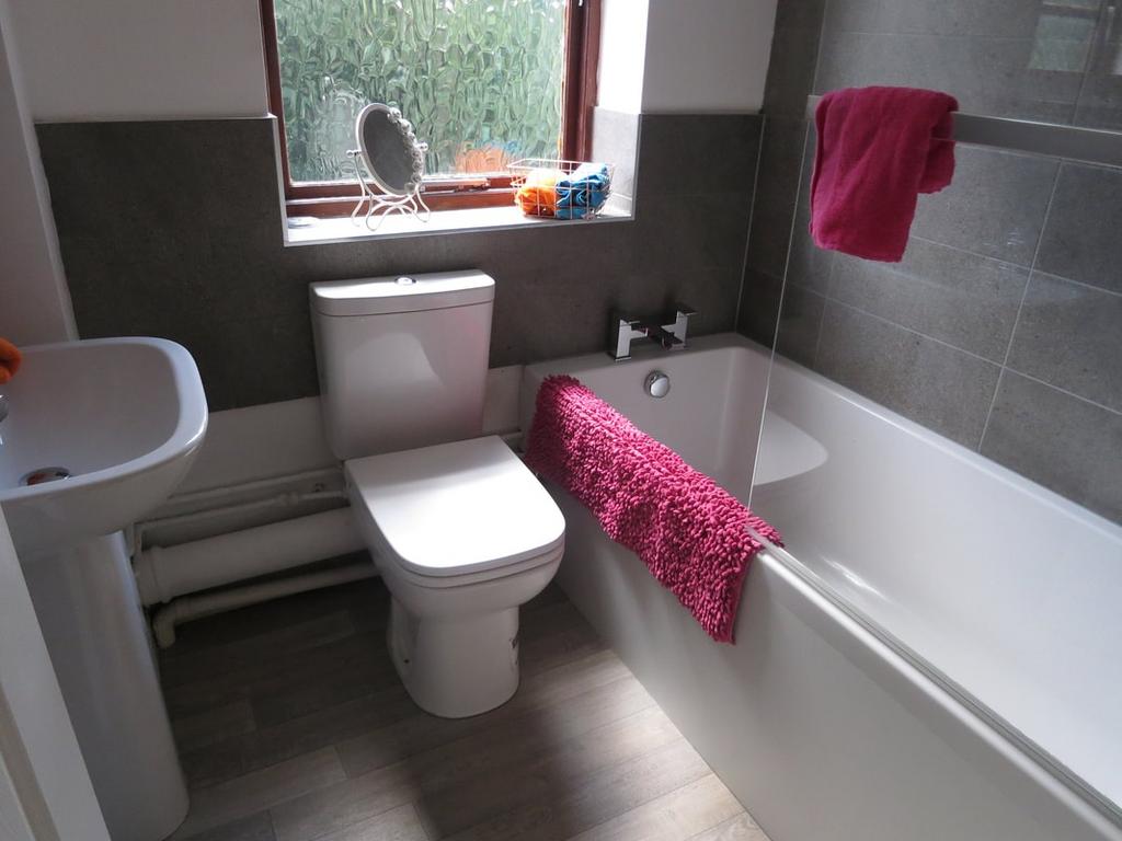 Bright, modern bathroom with a white bathtub an...