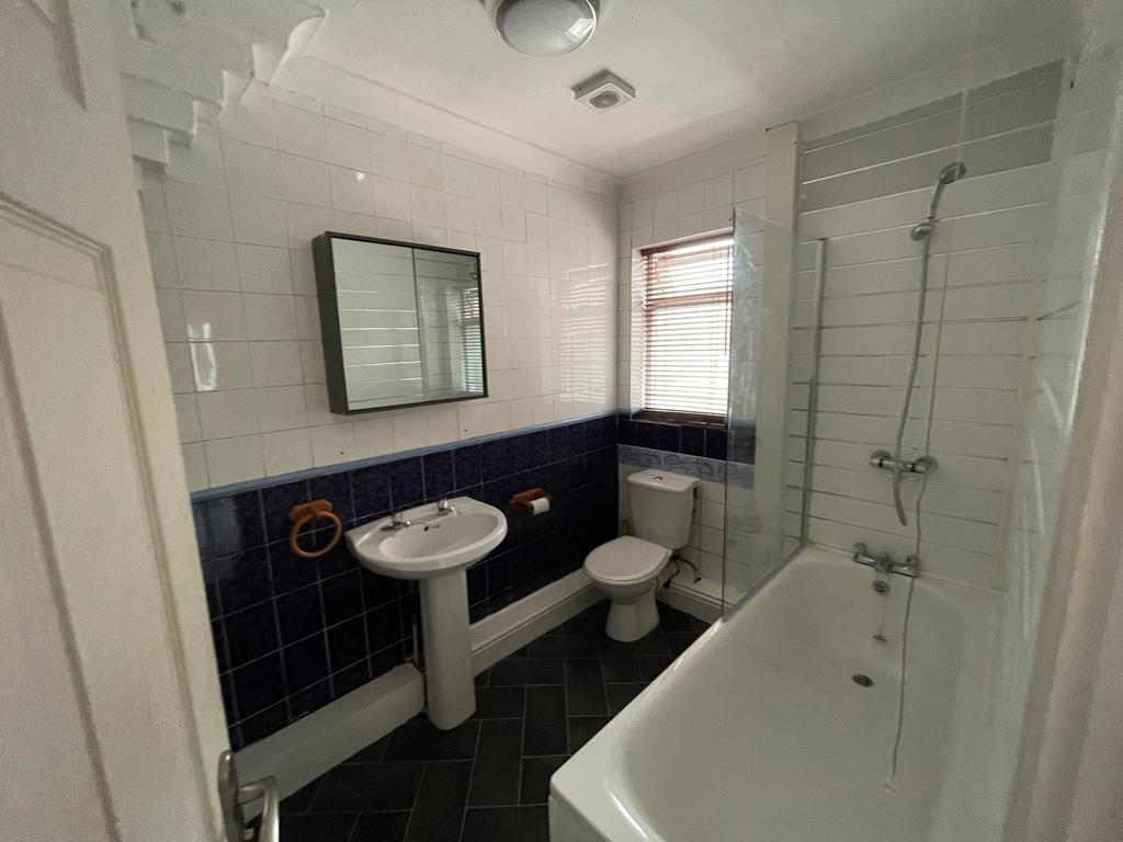 Well-equipped bathroom with a bathtub and overh...