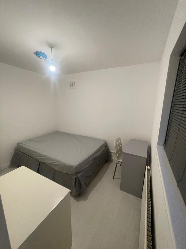 A simple, neatly arranged double bedroom featur...