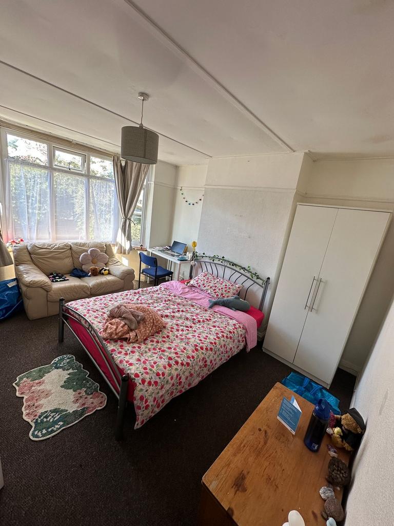 Spacious bedroom with sofa and natural light...