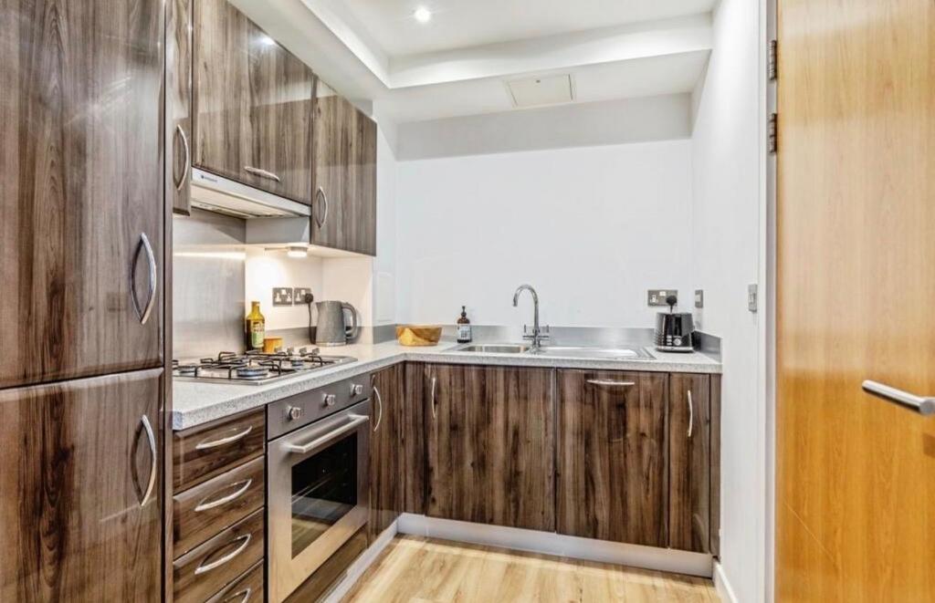 Modern fitted kitchen with wood-effect cabinetr...