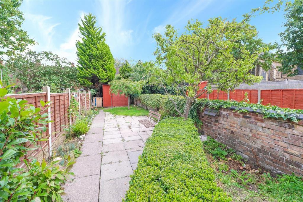 Sunny private garden with paved path and lawn...
