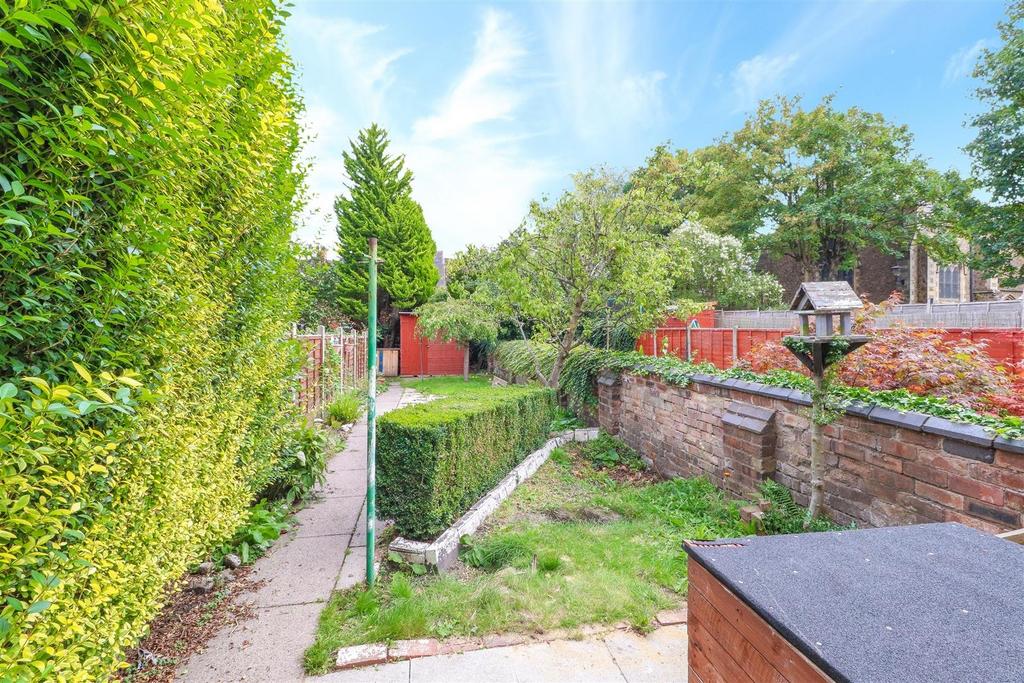 Sunny private garden with lawn and mature hedgi...