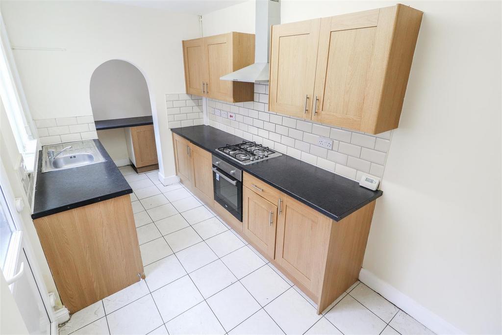 Bright kitchen with fitted units and tiled floo...