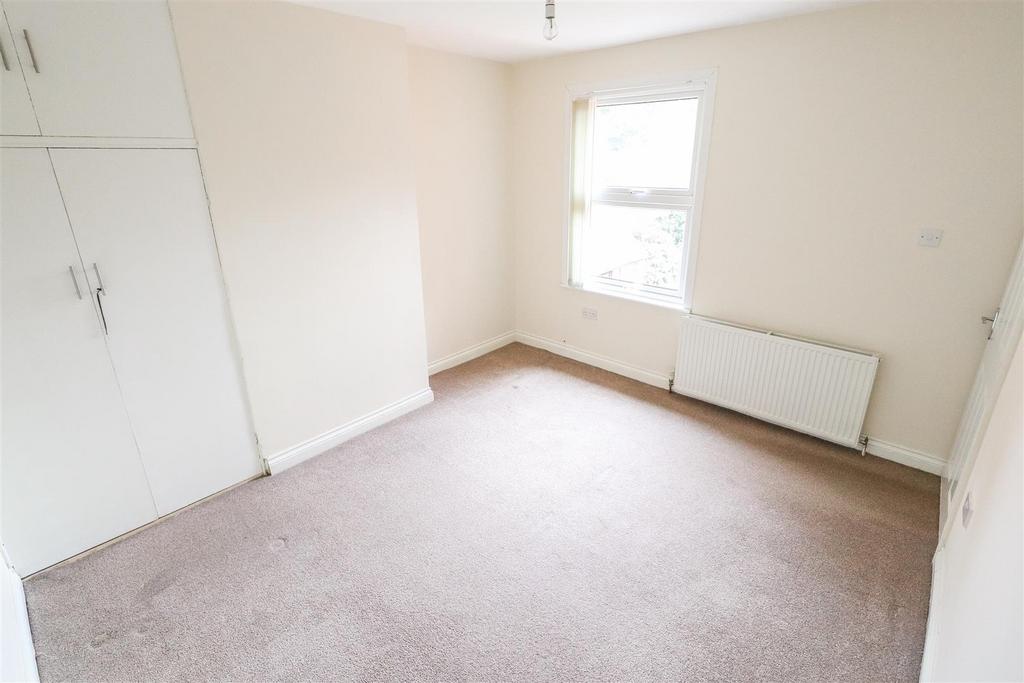 Bright bedroom with built‑in storage and neutra...