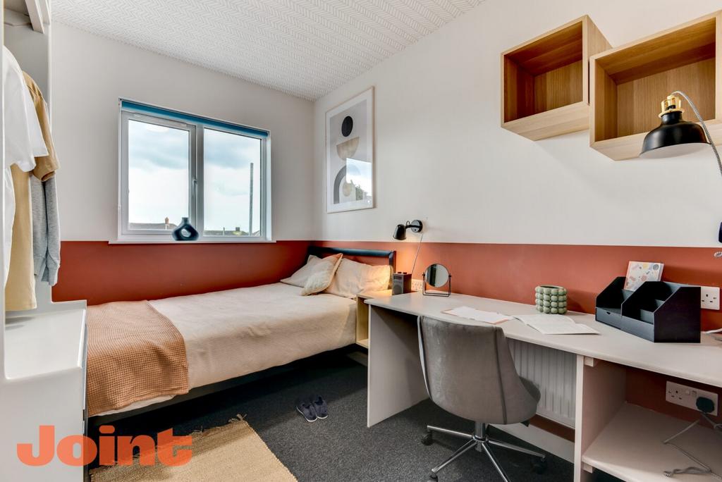 Bright, neatly styled single bedroom with a com...