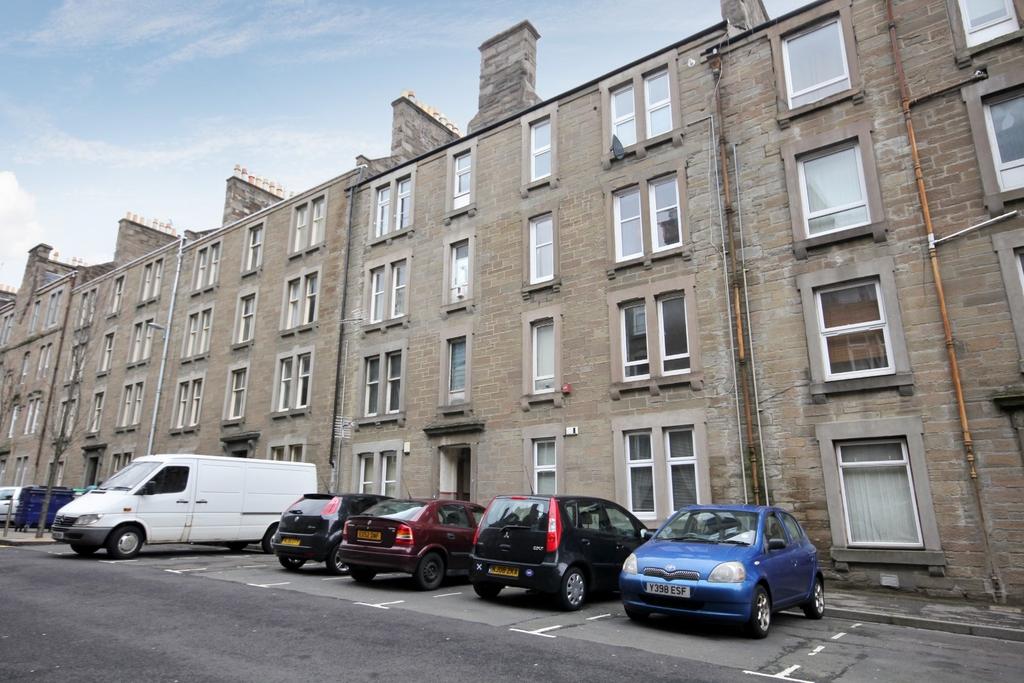 Traditional stone tenement with on-street parki...
