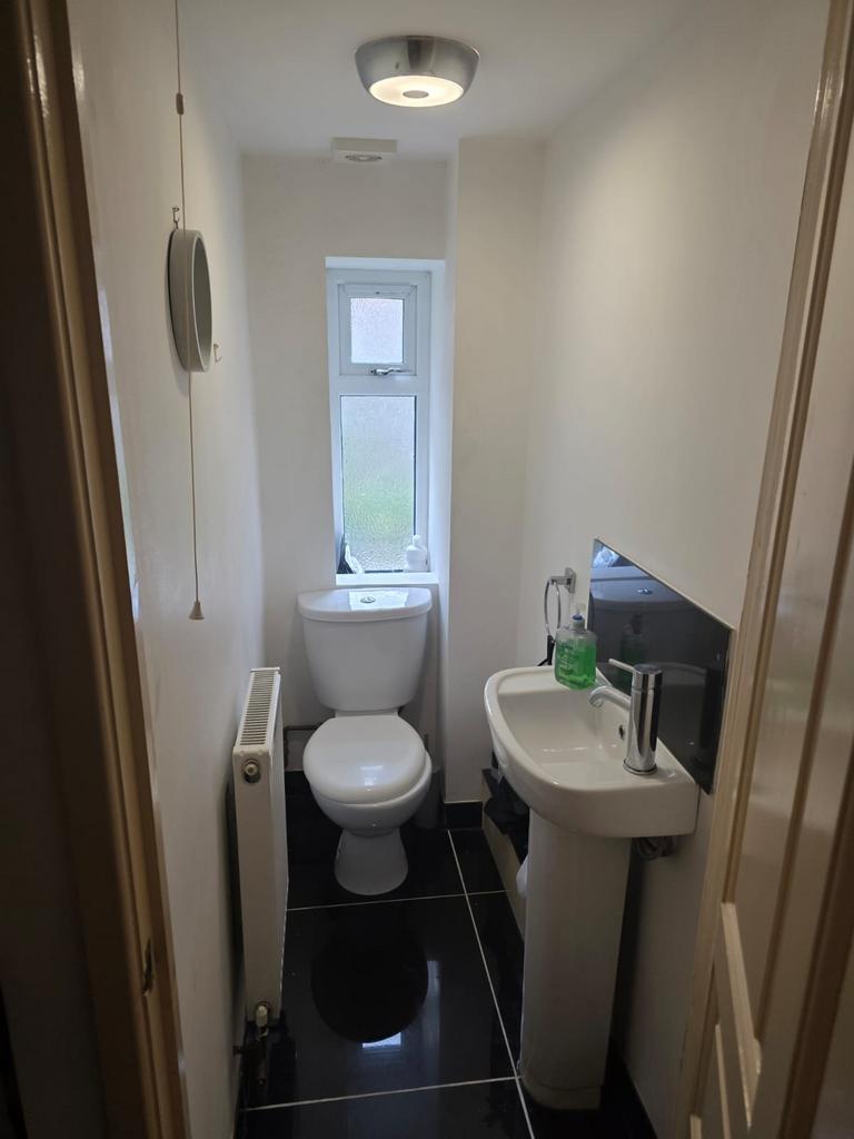 Neat, modern downstairs WC with glossy black ti...