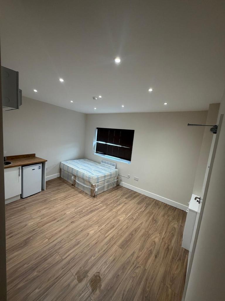 Modern studio room with sleek wood floors...