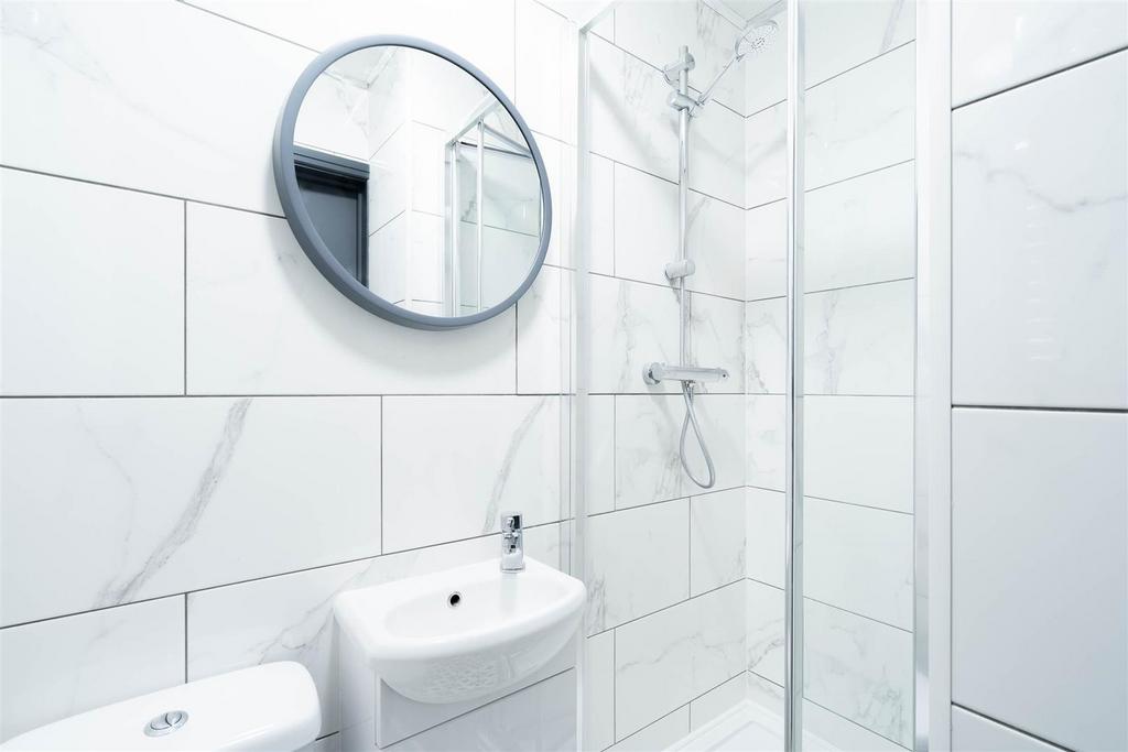 Bright modern bathroom with shower and clean ti...
