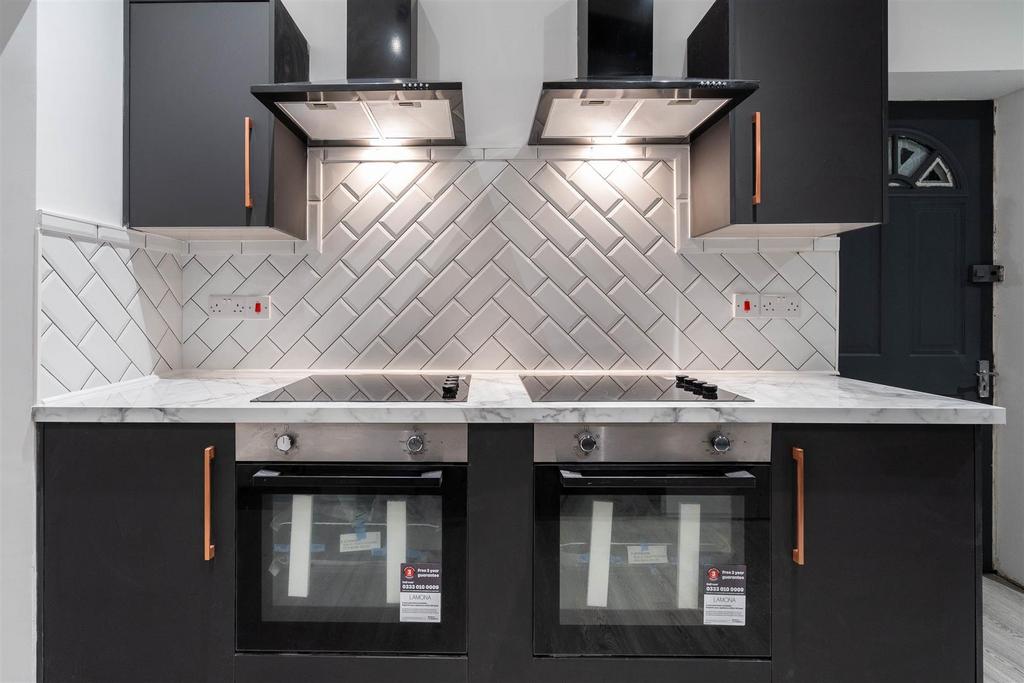 Modern kitchen with twin ovens and herringbone ...