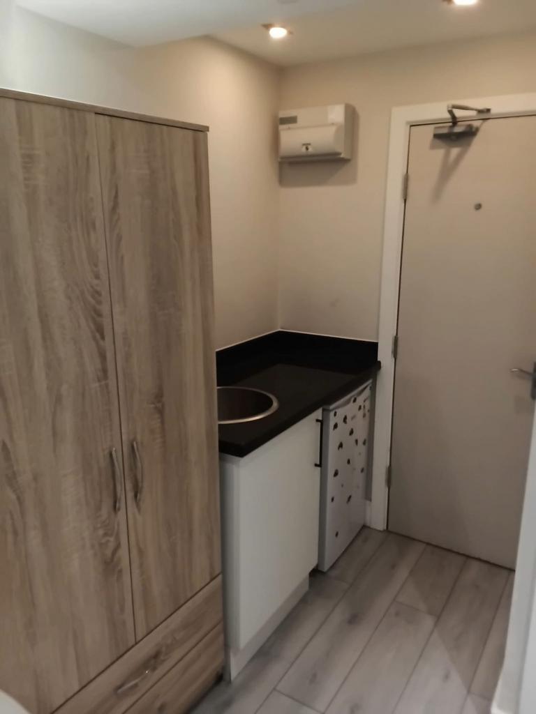 Modern kitchenette with sleek black worktops...