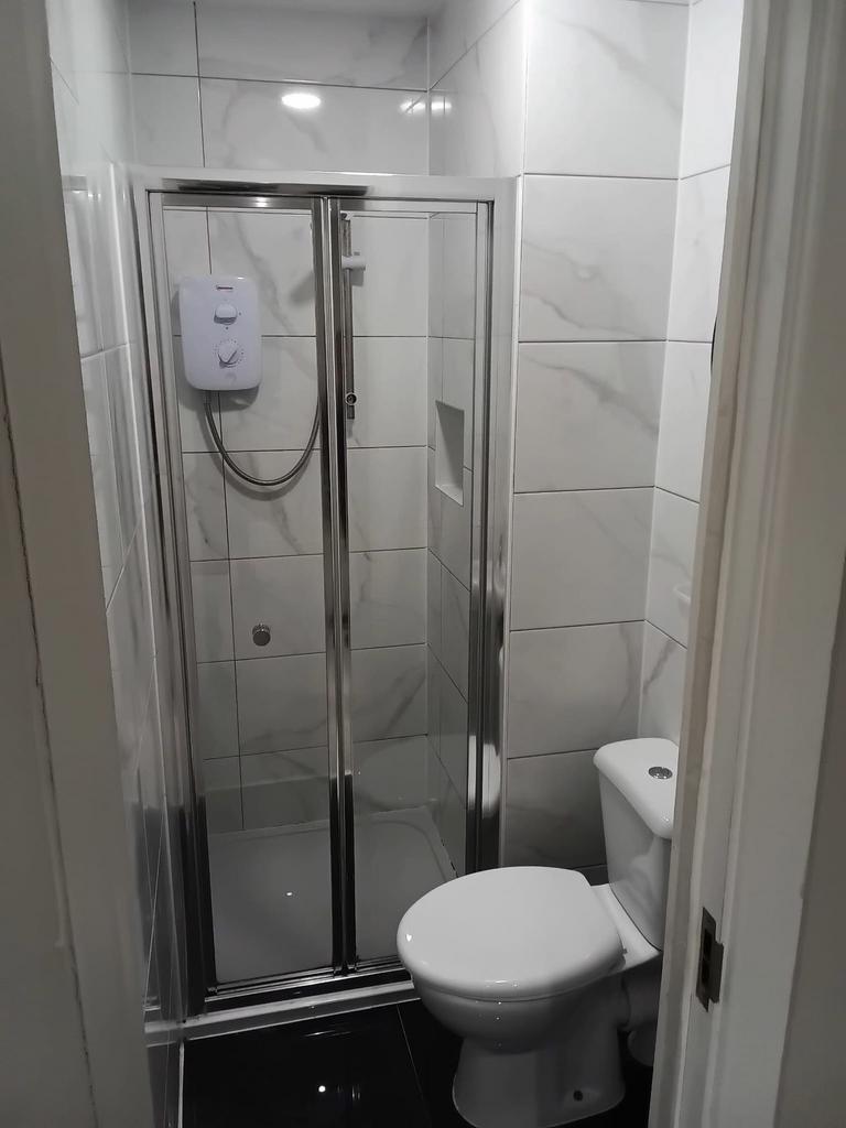 Modern shower room with sleek marble-effect til...