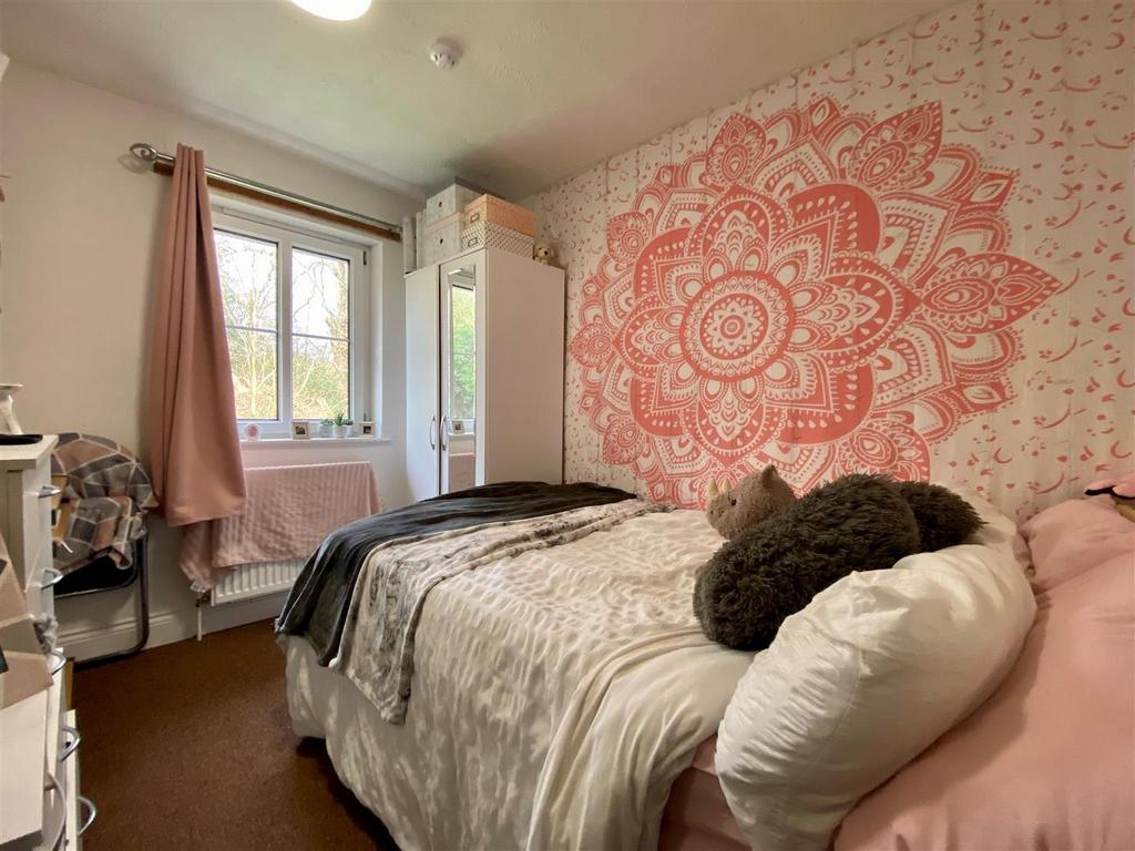 Cozy bedroom with patterned feature wall and so...